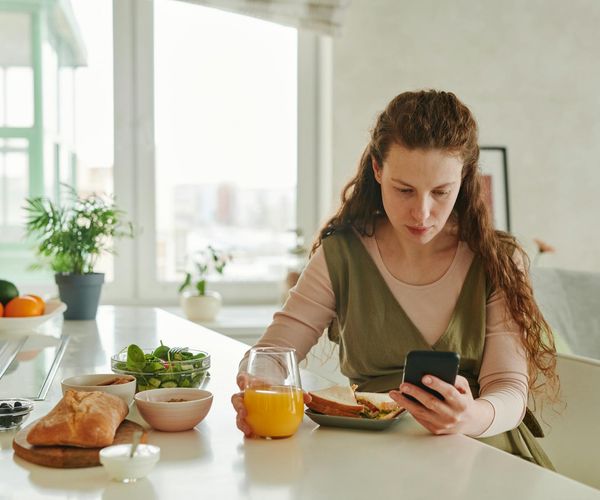 Person looking at a weekly planner with a healthy drink.