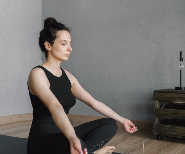 Person meditating peacefully in a calm, modern space.